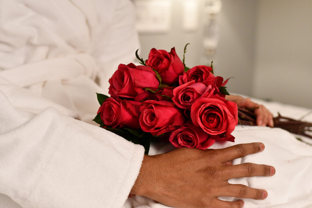 Someone holding a bouquet of red roses.